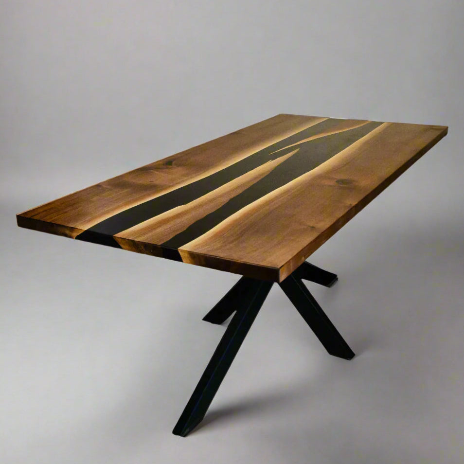 three quarter angle of a rectangular dining room table with two conjoining rivers of black epoxy in the middle.