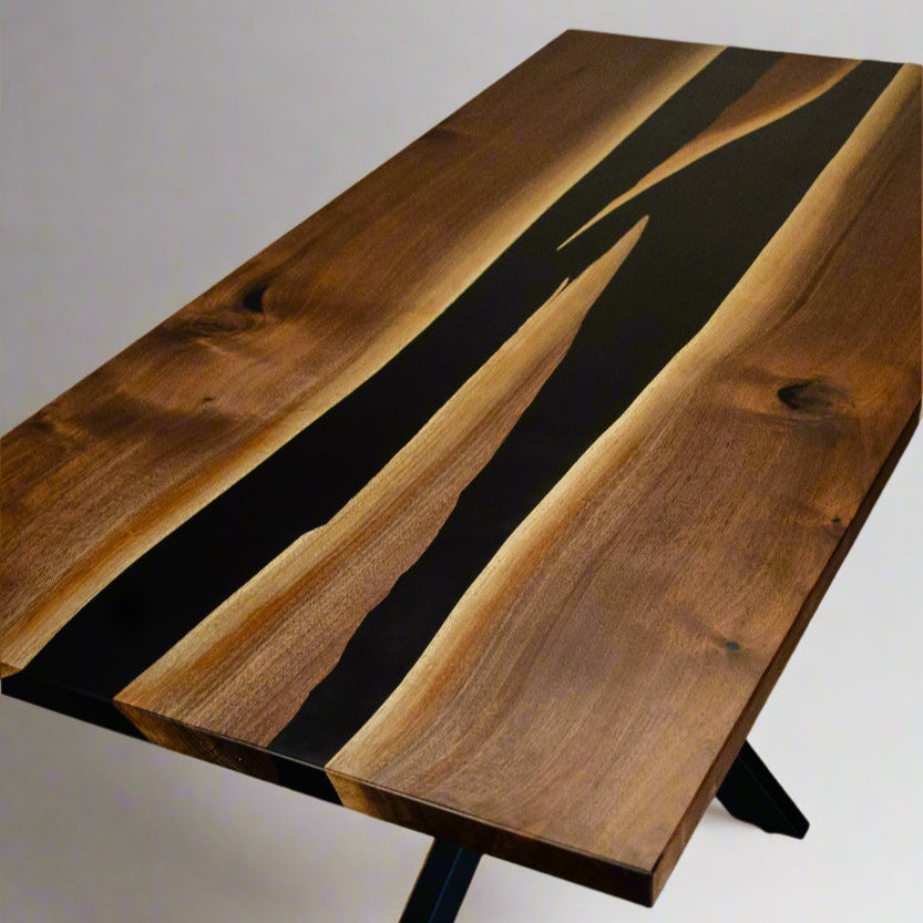 top down angle of a rectangular dining room table with two conjoining rivers of black epoxy in the middle.