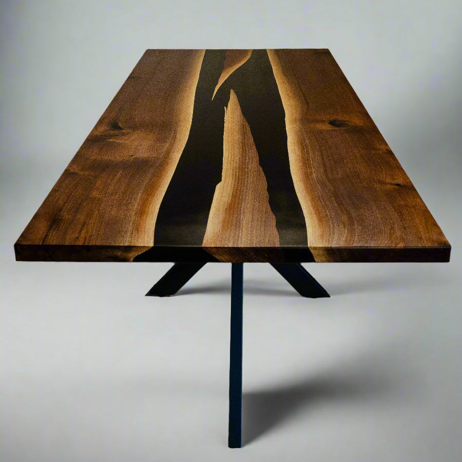 head on angle of a rectangular dining room table with two conjoining rivers of black epoxy in the middle.